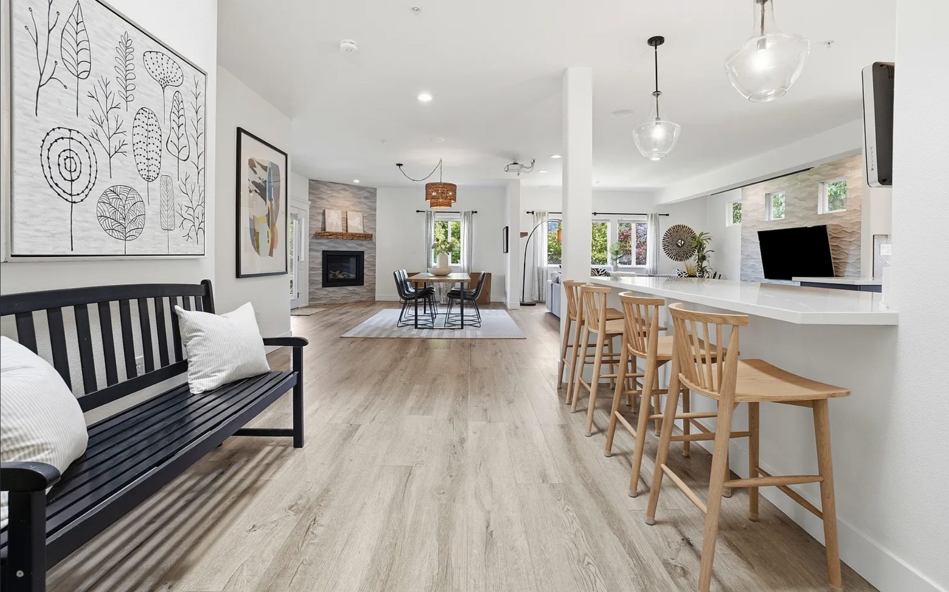 Open-concept great room in a turn-key San Rafael home with a quartz breakfast bar, dining area, and gas fireplace
